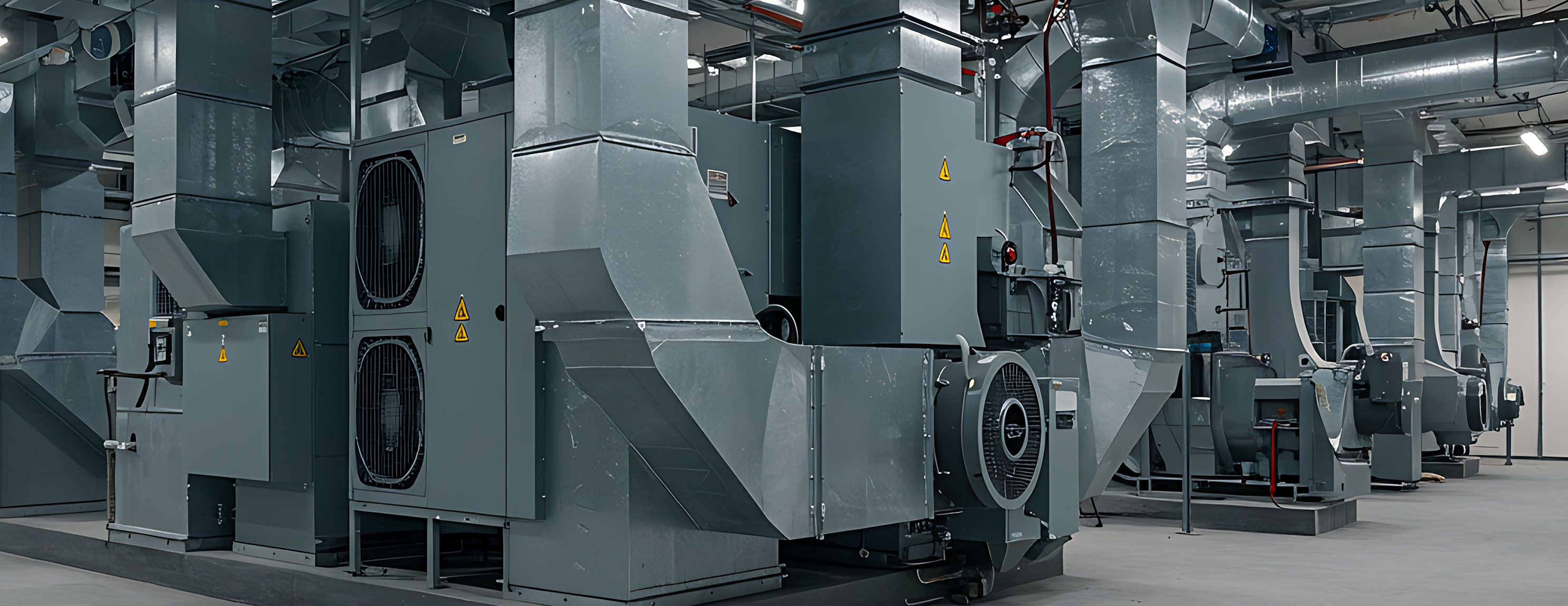 Große Lüftungsanlage mit mehreren Metallkanälen und Ventilatoren in einem technischen Raum
